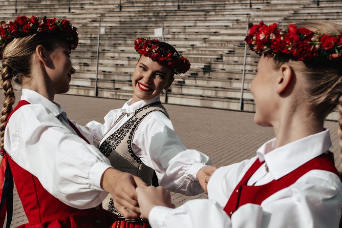 Trīs māsas sadevušās rokās tautastērpos pie Mežaparka estrādes kāpnēm