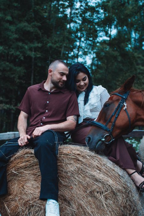 Couple photoshoot with two horses in a grain field