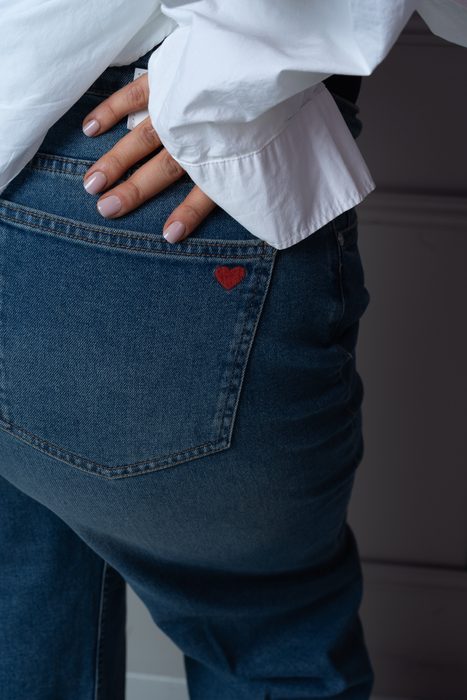 Roka uz džinsu kabatas portreta detaļā