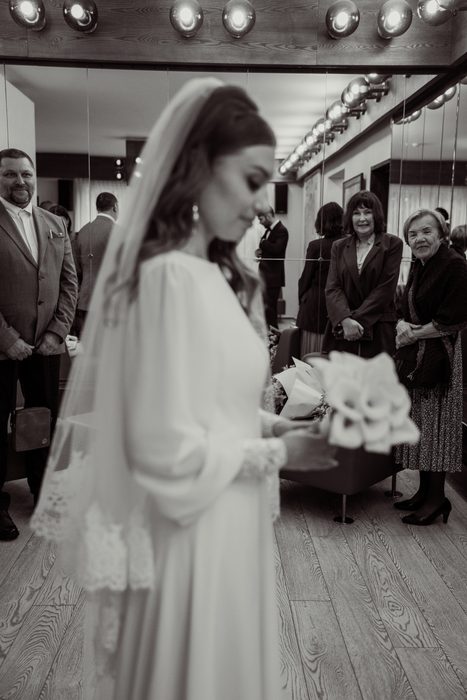Black and white photograph of the bride with a calla bouquet before the ceremony in Jūrmala