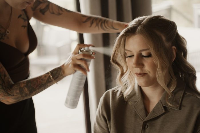 Bride having her hair styled before the ceremony
