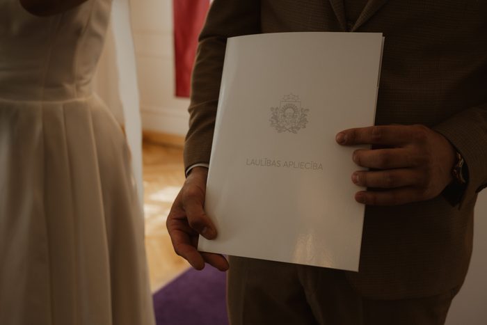 Groom holding the marriage certificate