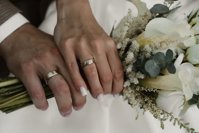 Close-up of newlyweds’ hands and rings