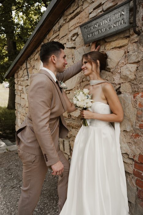 Newlywed portrait beside an old stone wall
