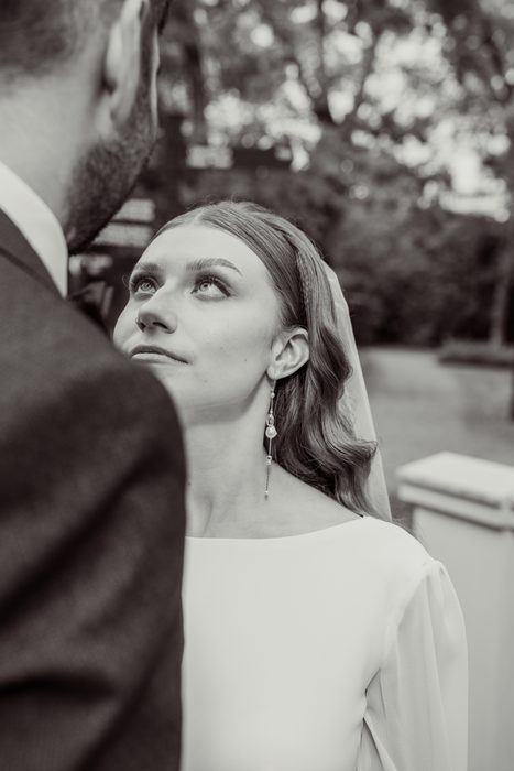 Black and white portrait of the bride looking up at the groom in Ķemeri Park