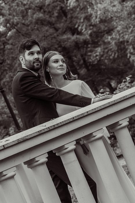 Black and white portrait of the couple at the white balustrade in Ķemeri Park
