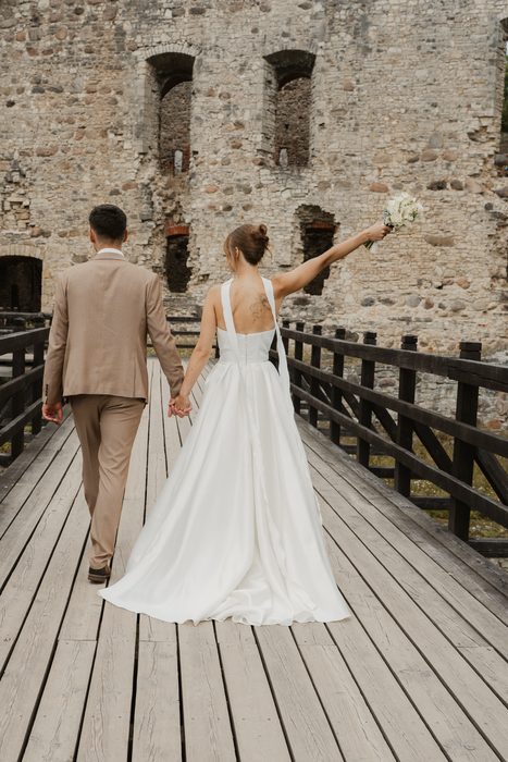 Wedding portraits on a wooden bridge beside castle walls