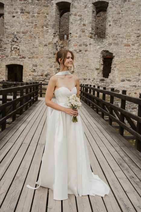 Wedding portraits on a wooden bridge beside castle walls