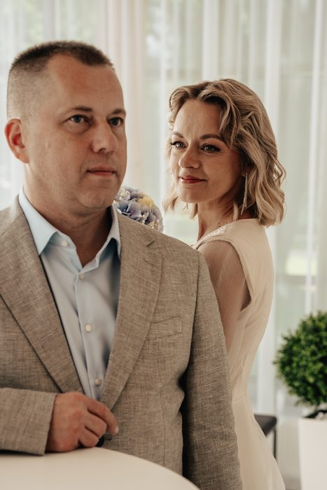 Groom in a grey suit in a bright ceremony room