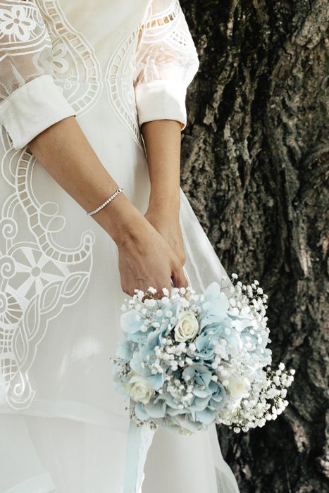 Bride holding a blue and white flower bouquet