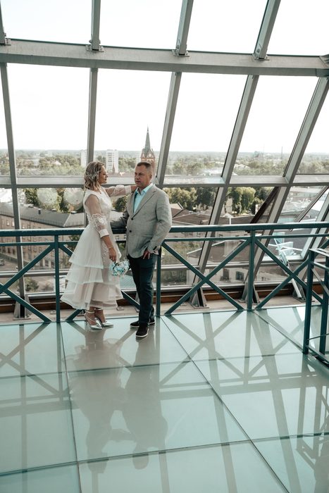 Wedding portraits beside tall windows and metal railings