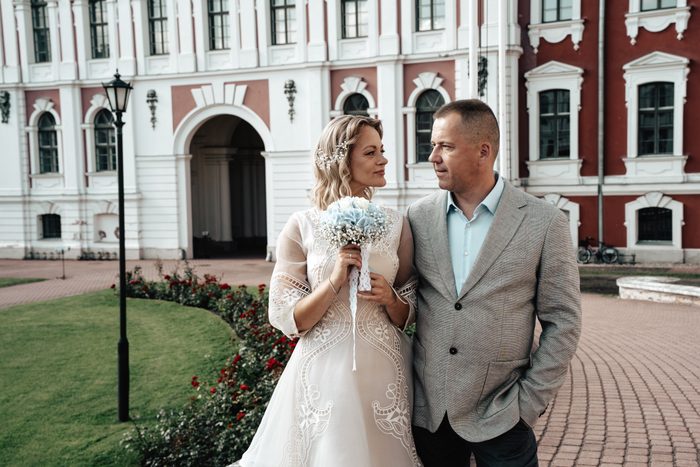 Newlyweds beside a colourful historic building