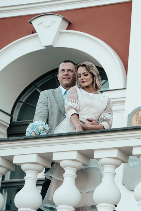 Newlyweds beside a colourful historic building
