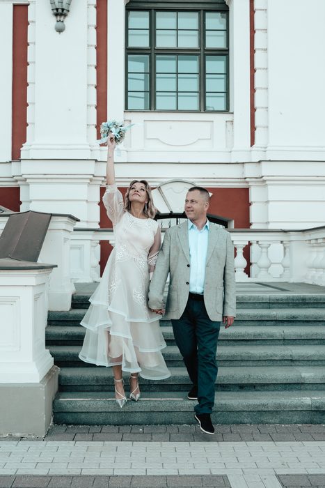 Newlyweds beside a colourful historic building
