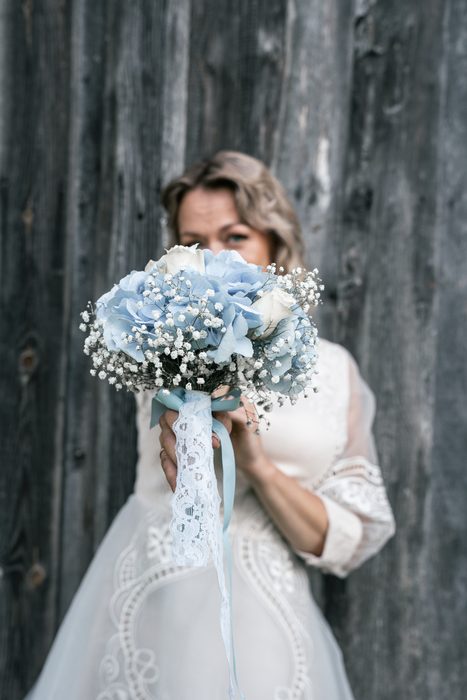 Bride holding a blue and white flower bouquet