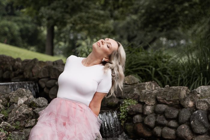Woman in a pink skirt holding pink flowers