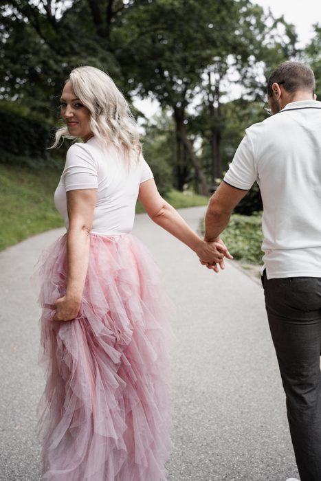 Couple holding hands on a walk through a park