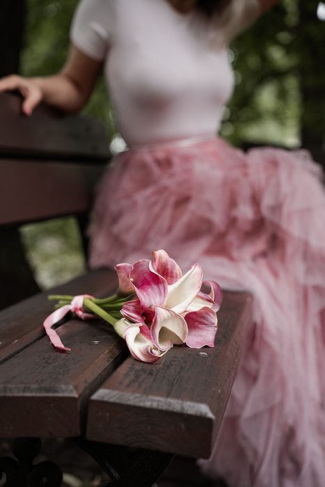 Woman in a pink skirt holding pink flowers